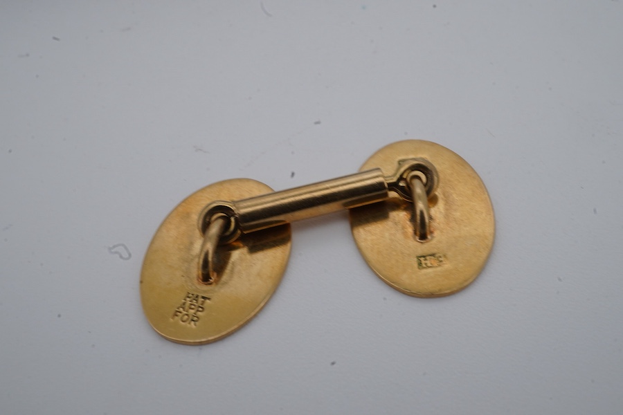 A pair of gold cuff-links, each end of oval outline with striped engraving, to a bar connector, each end 1.8cm, each stamped 18ct, combined gross weight approximately 9.5 grams, maker's marks EH, case stamped Jay's, Cond